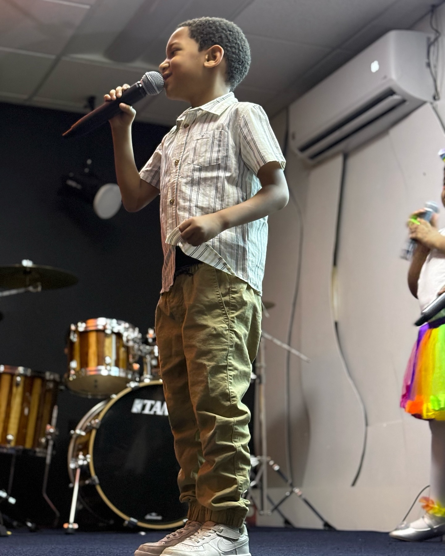 Niño cantando en la plataforma de Revive Church